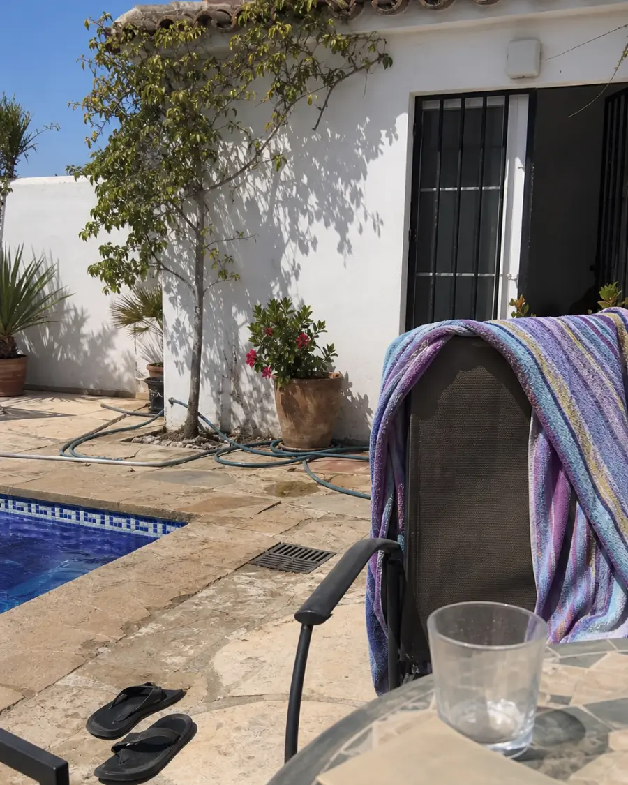 A whitewashed Spanish house with a terrace and a small sensor under the eaves