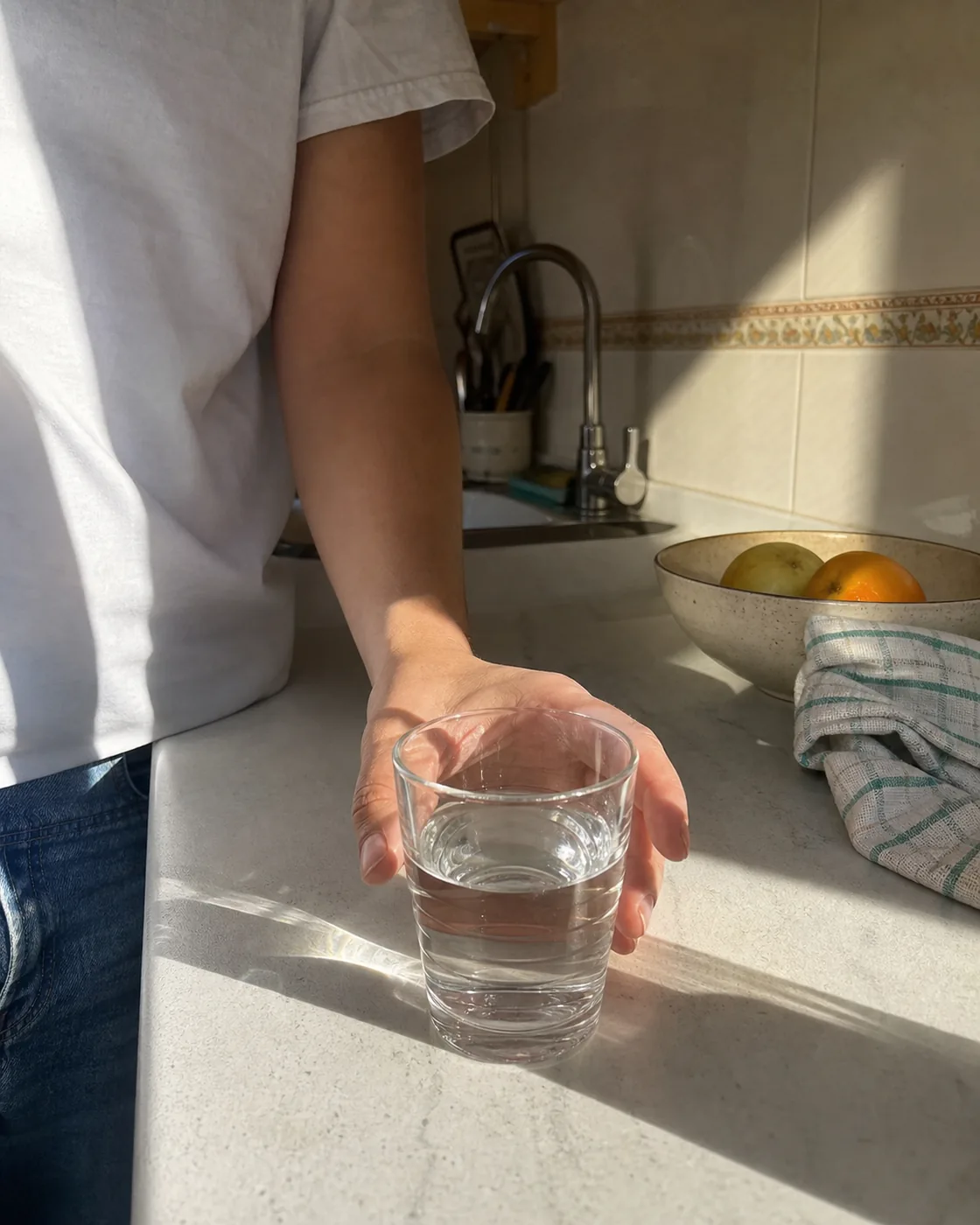 A glass of clear tap water on a sunny kitchen counter in Málaga